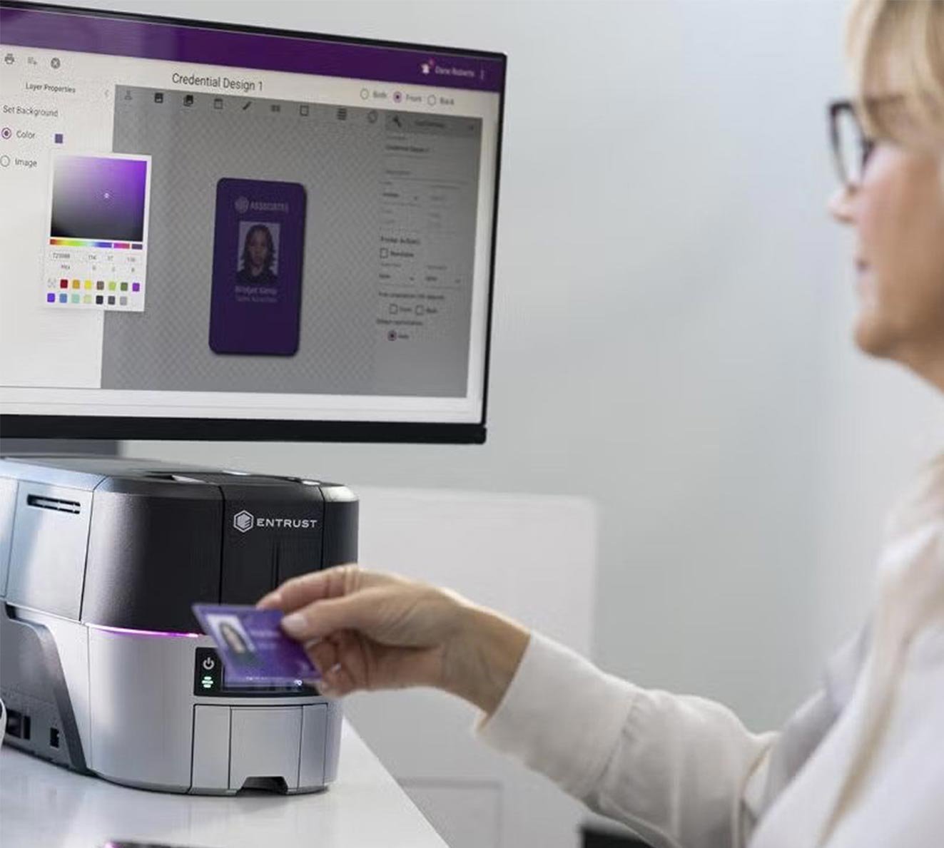 Person-swiping-a-purple-ID-card-into-an-Entrust-card-printer